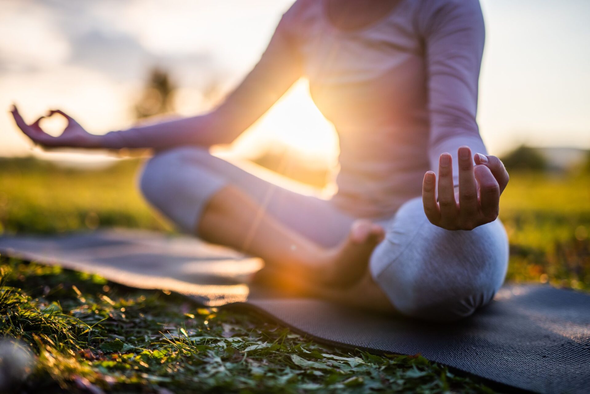 Persona meditando en un parque durante el amanecer