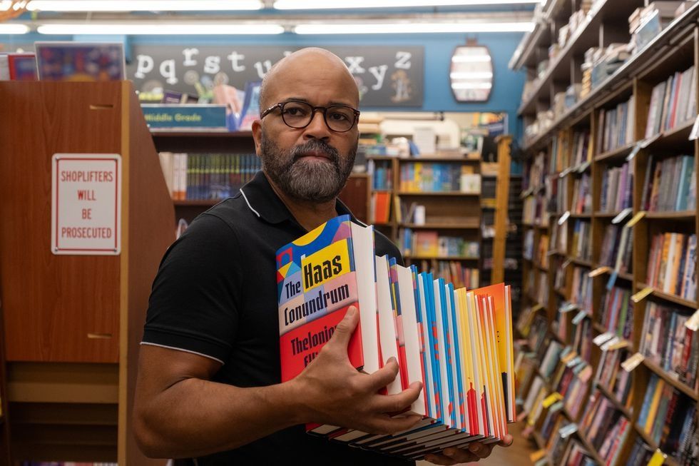 un hombre sosteniendo un libro en una biblioteca