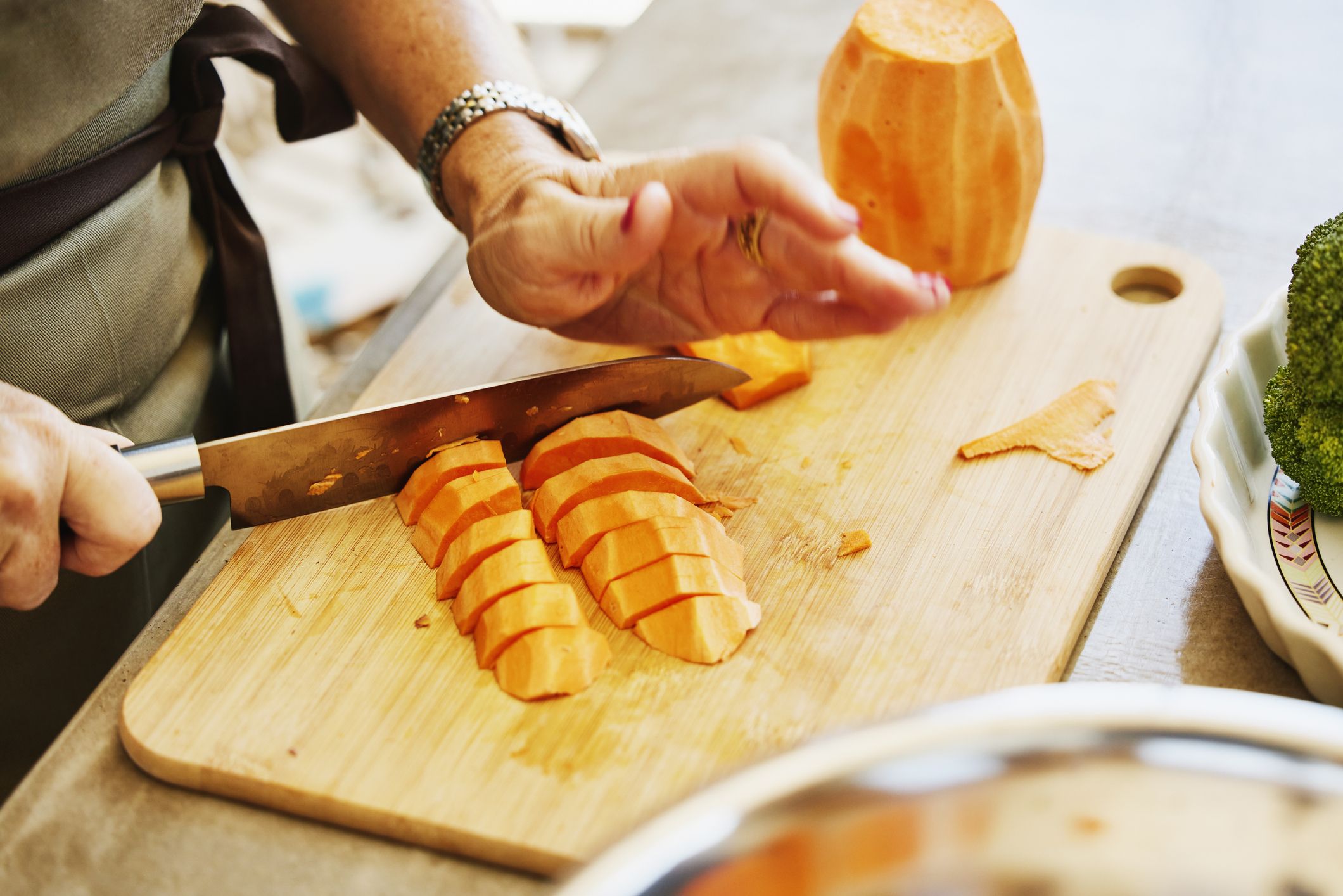 primer plano de una mujer cortando batatas durante la clase de cocina