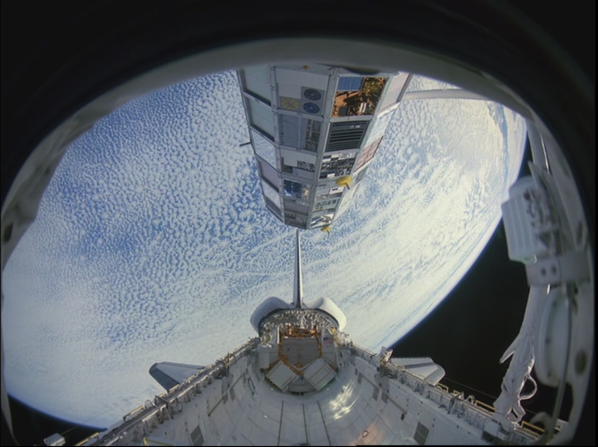 El astronauta de STS-41C, Terry J. Hart, levanta la Instalación de exposición de larga duración (LDEF) fuera del compartimento de carga útil del Challenger.