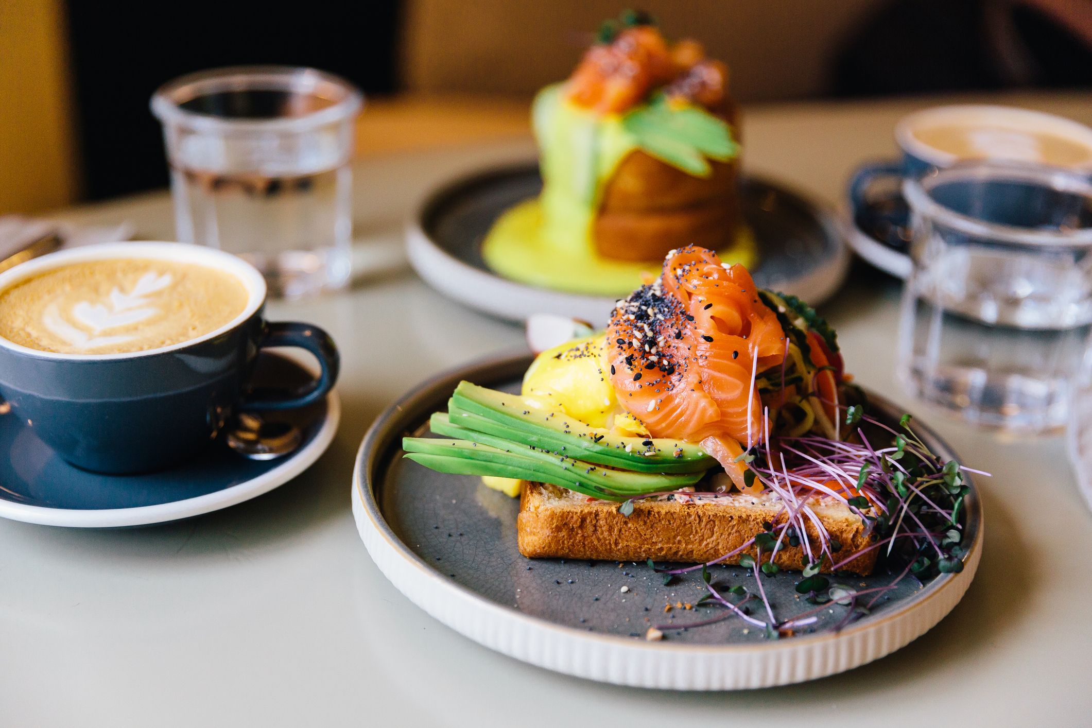 tostadas de aguacate con salmón y huevo escalfado servidas para el desayuno en una cafetería