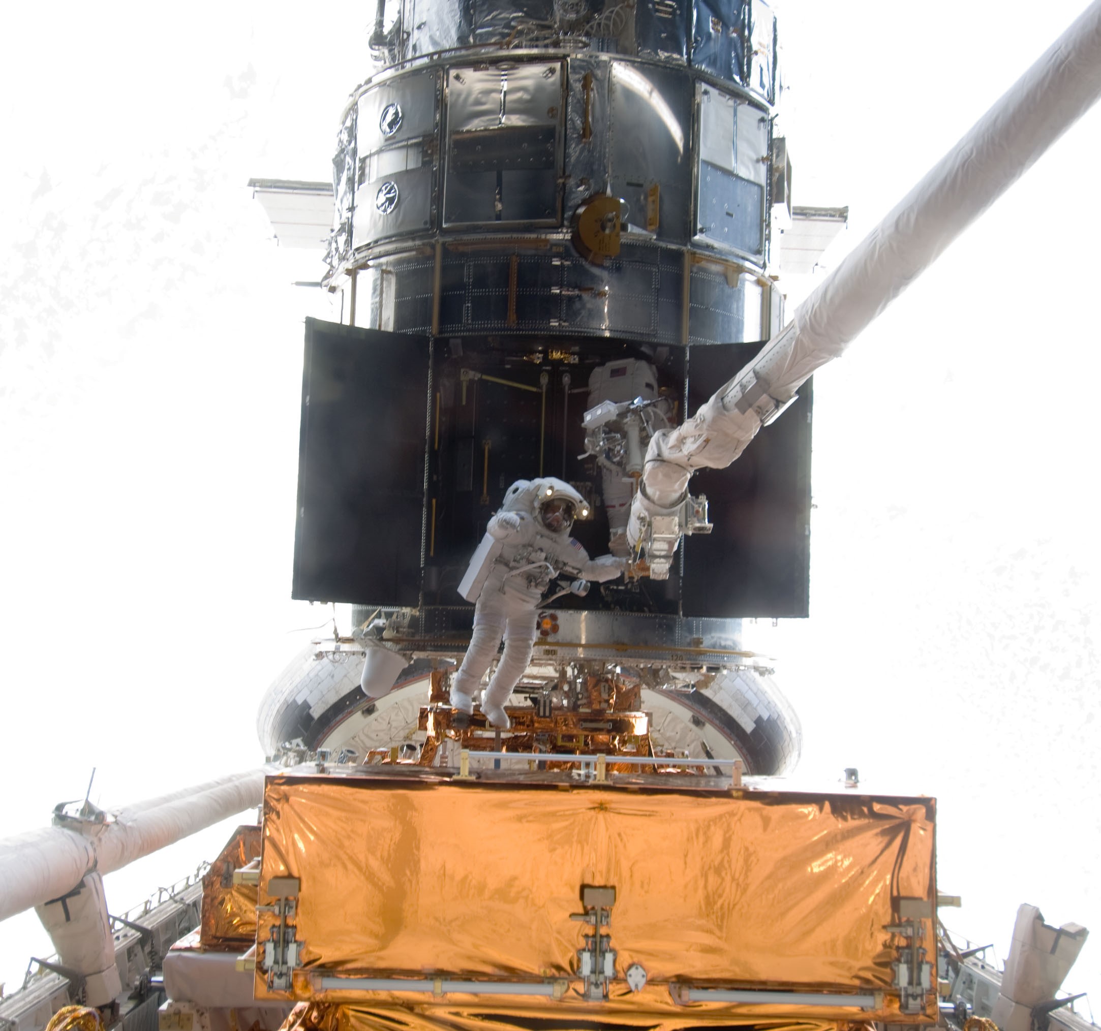 Andrew J. Feustel, izquierda, y John M. Grunsfeld retiran el instrumento de reemplazo axial del telescopio espacial de óptica correctiva (COSTAR)