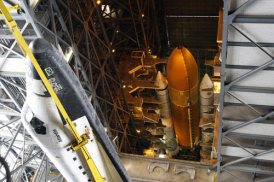 En el edificio de ensamblaje de vehículos (VAB) del Centro Espacial Kennedy de la NASA en Florida, los trabajadores levantan el Atlantis para acoplarlo a su tanque externo y a sus propulsores de cohetes sólidos.