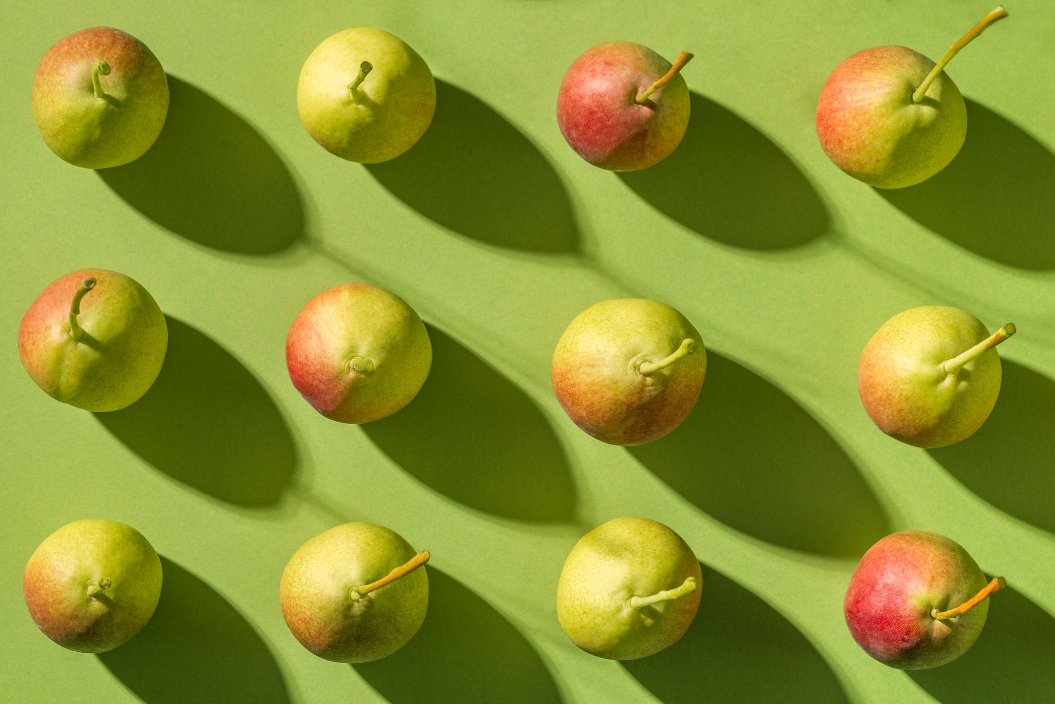 patrón de peras disposición de frutas en un ritmo de fila con sombras fondo verde plano mínimo