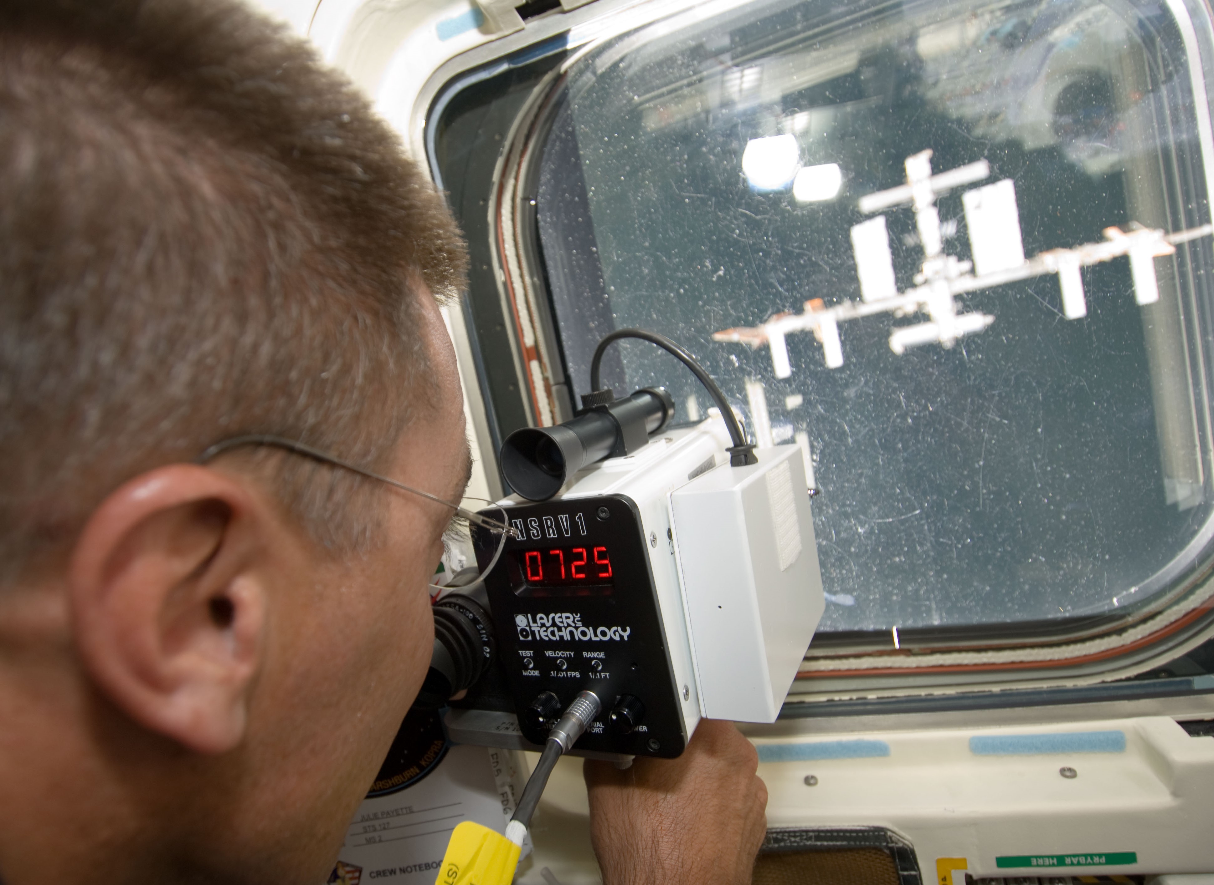 El astronauta de la NASA Christopher J. Cassidy utiliza un telémetro láser durante el encuentro del Endeavour con la estación espacial