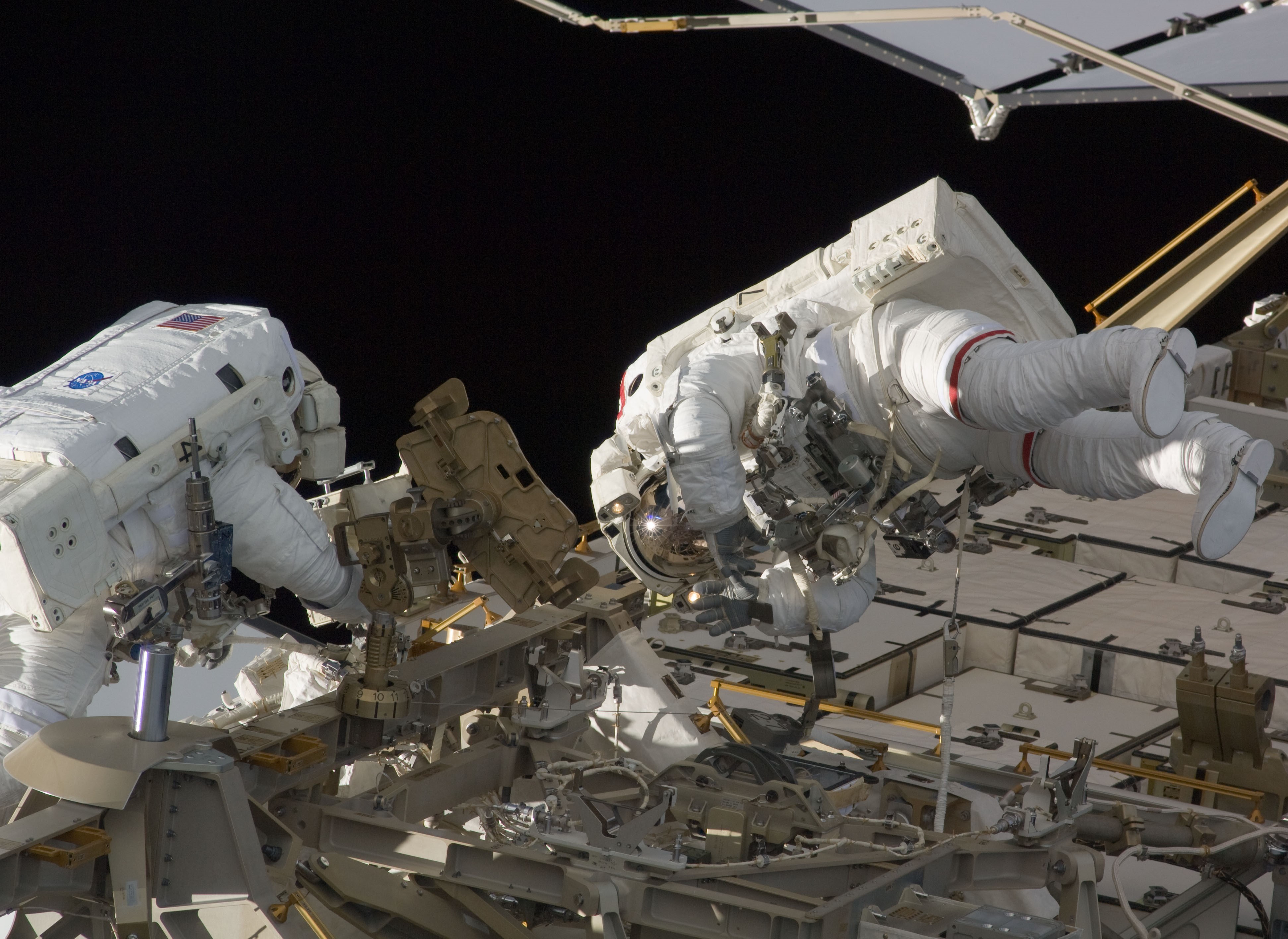 Timothy L. Kopra, a la izquierda, y David A. Wolf trabajan en la estructura de la estación durante la primera caminata espacial de la misión.