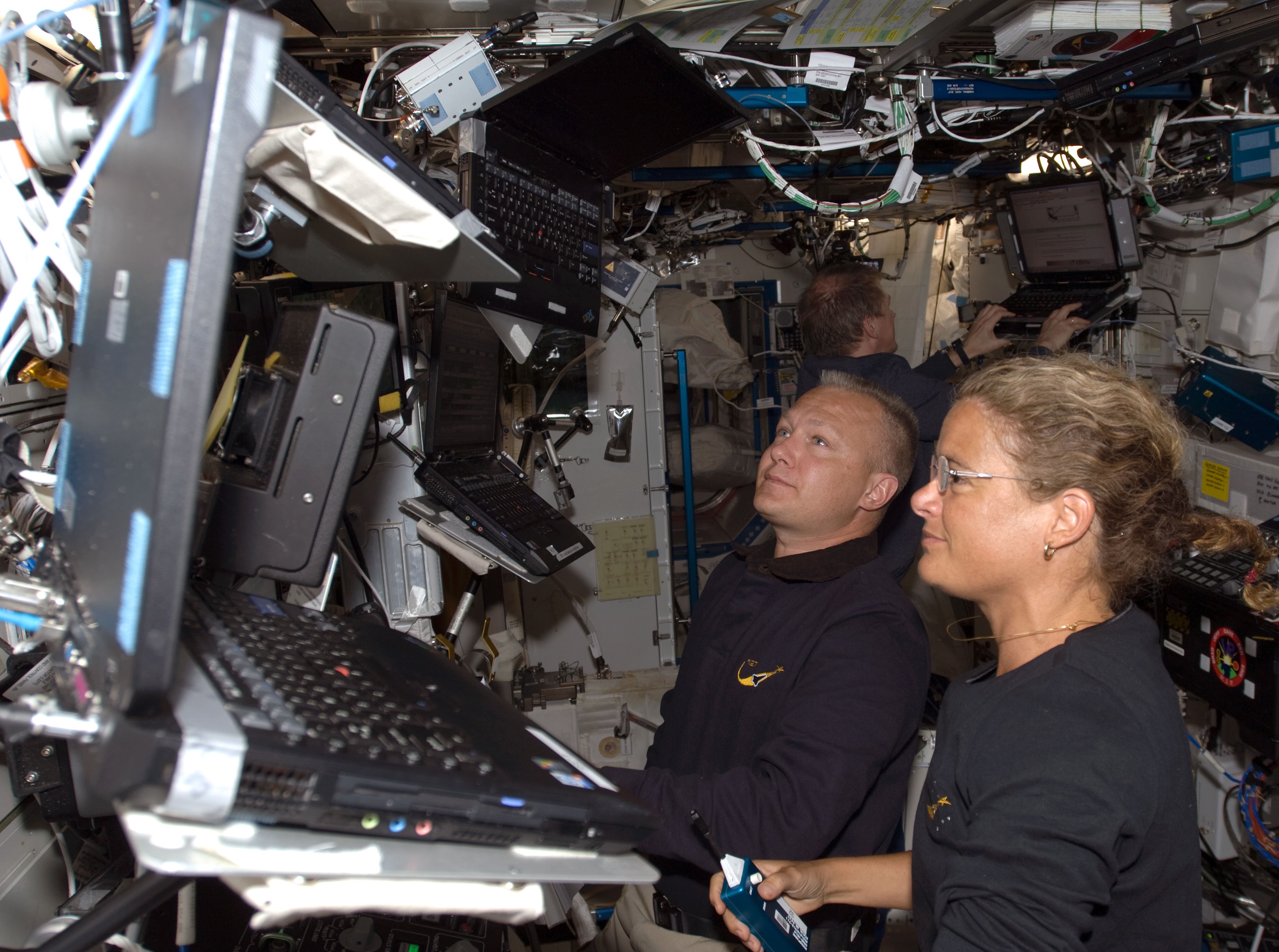 El astronauta de la NASA Douglas G. Hurley, a la izquierda, y la astronauta de la Agencia Espacial Canadiense Julie Payette operan el brazo robótico de la estación durante la segunda caminata espacial.