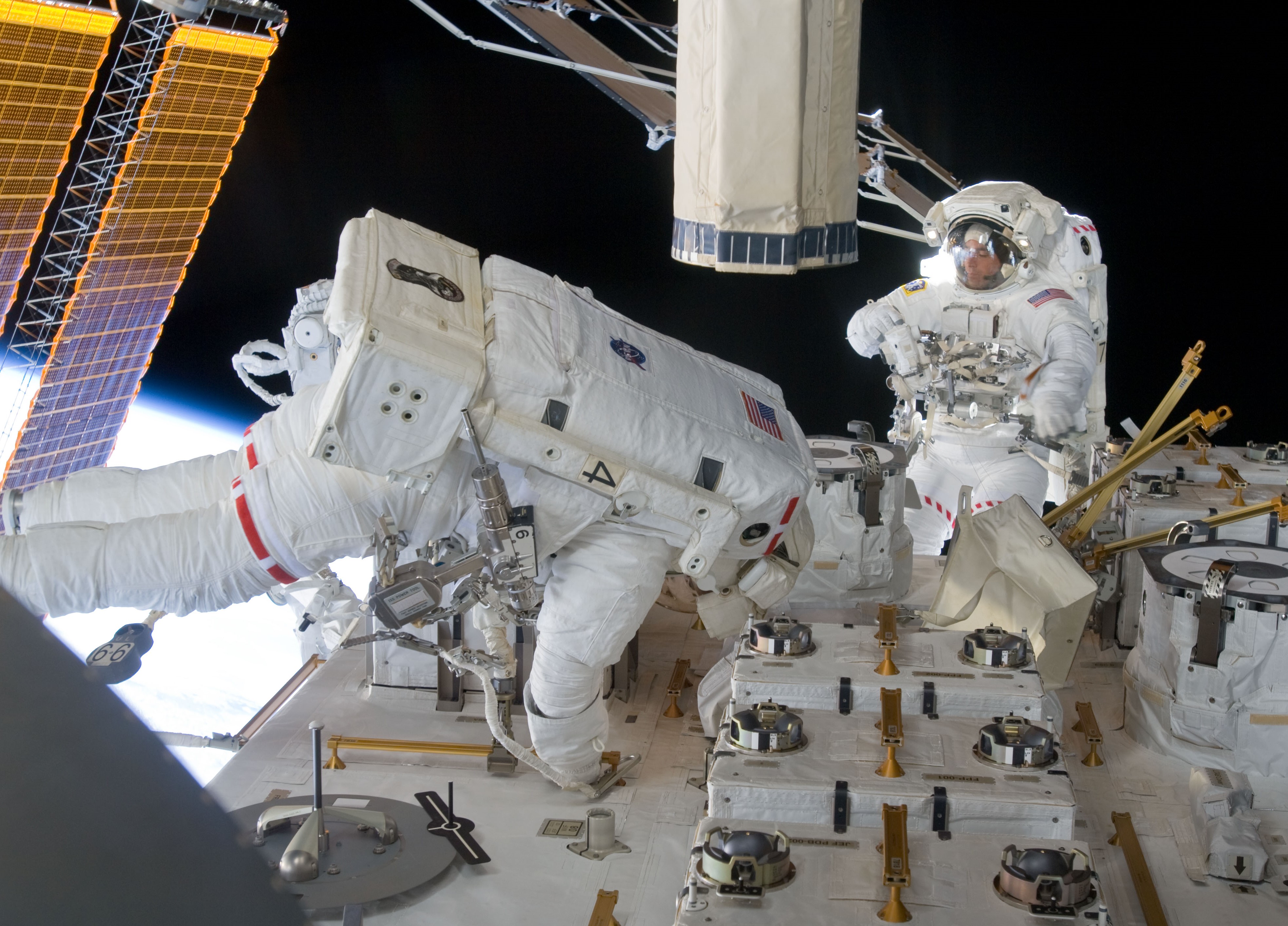 Marshburn, a la izquierda, y Cassidy instalan cámaras en la instalación expuesta de Kibo durante la quinta y última caminata espacial.