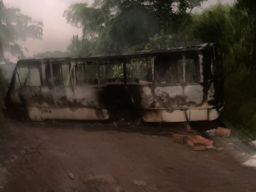 Camión de pasajeros incendiado bloqueando la carretera