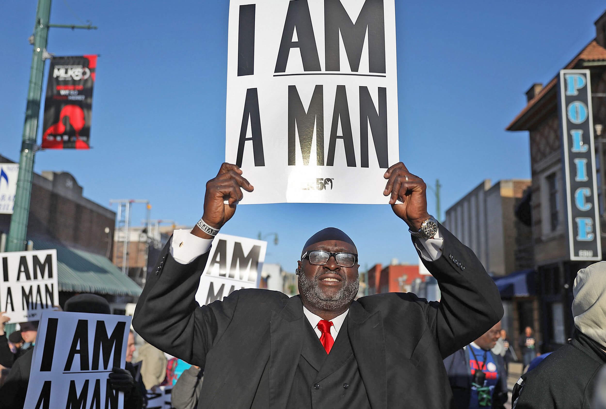 Un hombre sostiene un cartel que reza I am a man