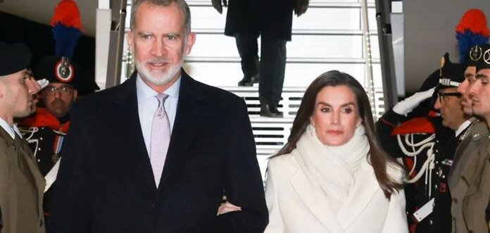 La reina Letizia sorprende en su llegada a Italia con un impoluto look blanco: abrigo largo y zapatos metalizados